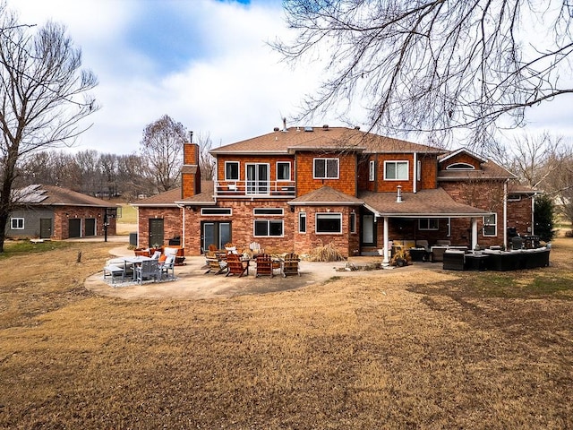 back of house with a lawn, a patio area, and a balcony