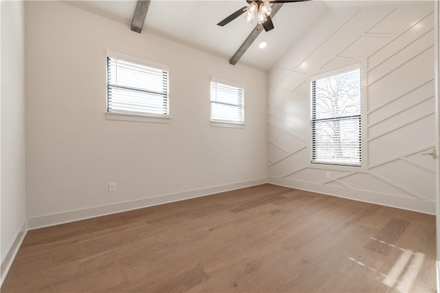 spare room featuring hardwood / wood-style floors, vaulted ceiling with beams, and plenty of natural light