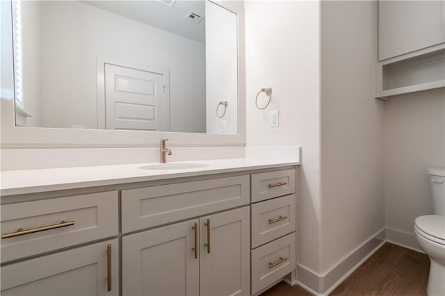 bathroom featuring hardwood / wood-style floors, vanity, and toilet