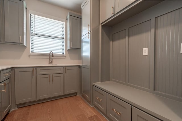 mudroom with sink and light hardwood / wood-style flooring