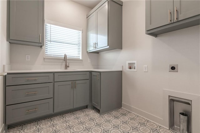 laundry room with cabinets, washer hookup, electric dryer hookup, sink, and light tile patterned flooring