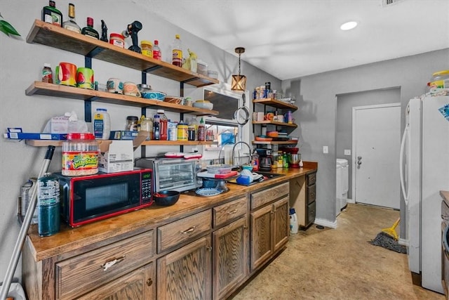 kitchen featuring washer / dryer, white refrigerator, hanging light fixtures, and sink