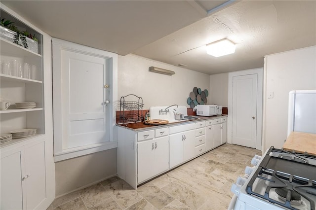 kitchen featuring sink, white cabinets, and white appliances