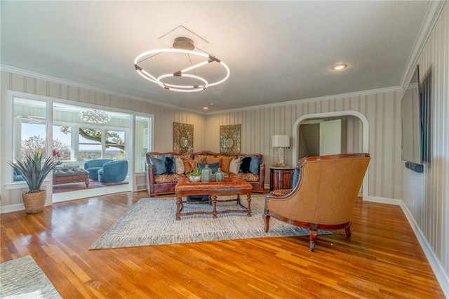 living room with crown molding, a chandelier, and hardwood / wood-style flooring