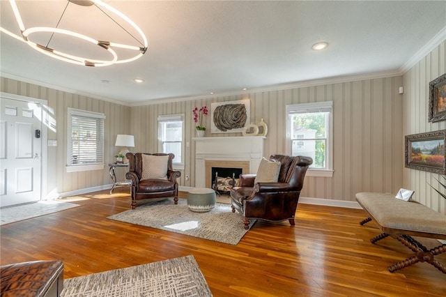 sitting room featuring wood-type flooring, crown molding, and a wealth of natural light