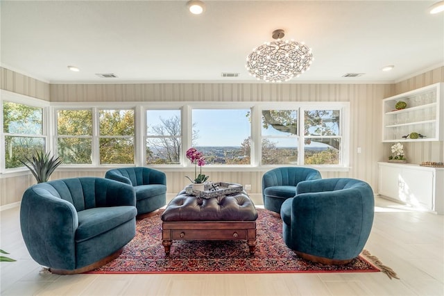 living room featuring crown molding and an inviting chandelier