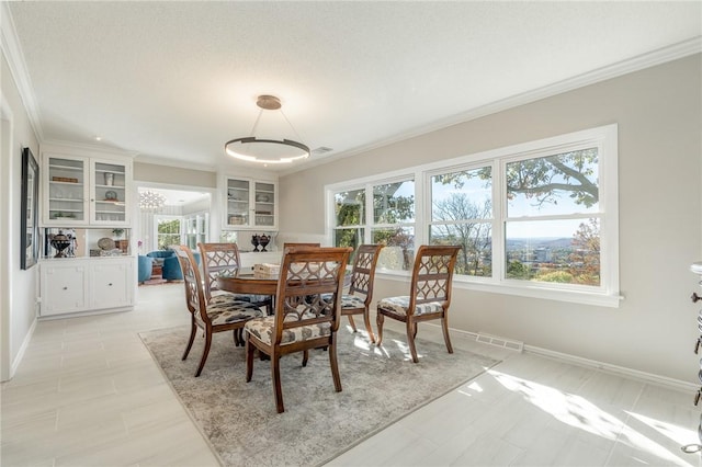 dining space with built in features and ornamental molding