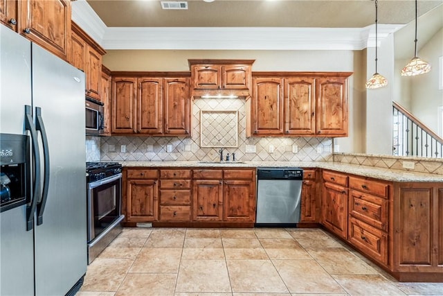 kitchen featuring backsplash, light stone counters, hanging light fixtures, and stainless steel appliances