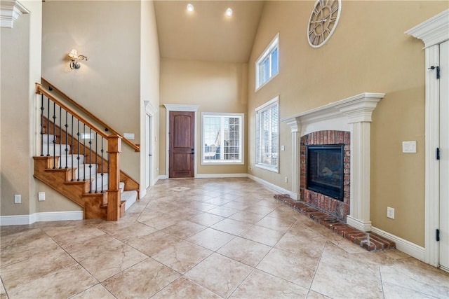 interior space with a towering ceiling and a brick fireplace