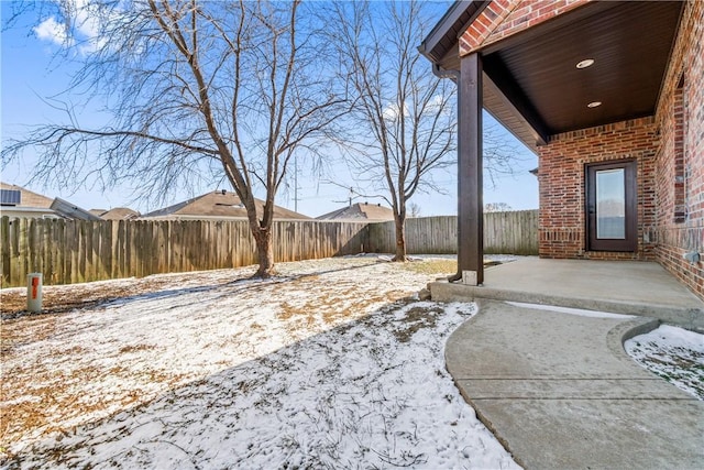 yard covered in snow featuring a patio