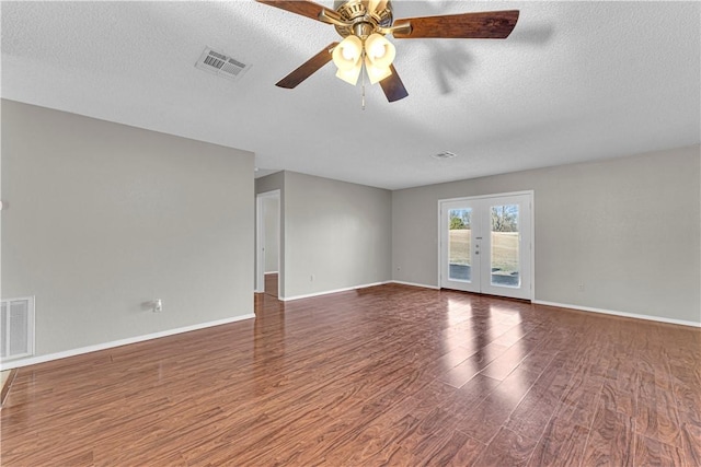 spare room featuring ceiling fan, dark hardwood / wood-style flooring, a textured ceiling, and french doors