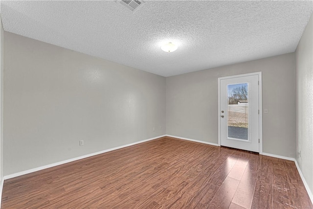 unfurnished room with dark hardwood / wood-style floors and a textured ceiling