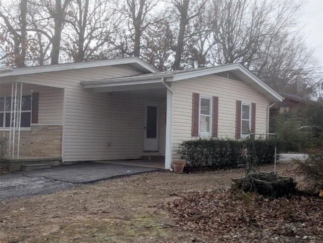 exterior space with a carport, covered porch, and driveway