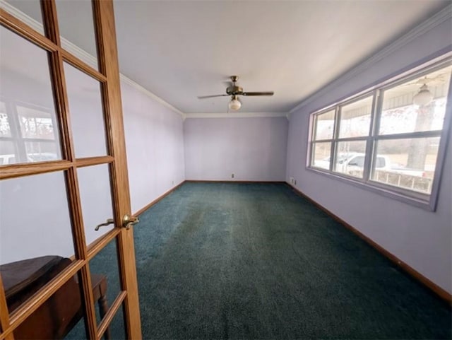 empty room featuring baseboards, dark carpet, a ceiling fan, and crown molding