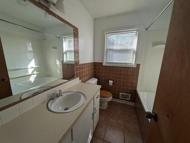 full bath with vanity, shower / tub combination, toilet, and tile walls