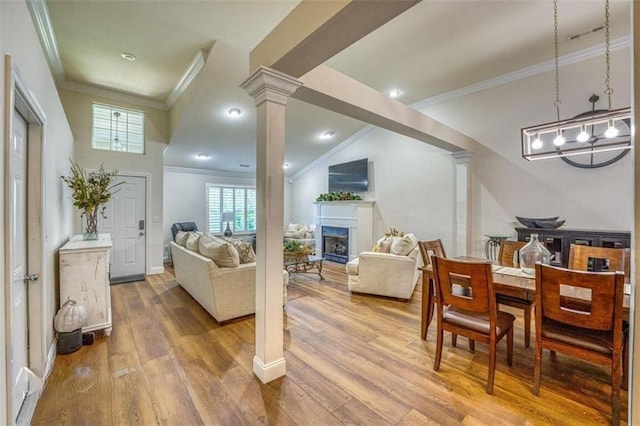 interior space with hardwood / wood-style flooring, ornate columns, and ornamental molding