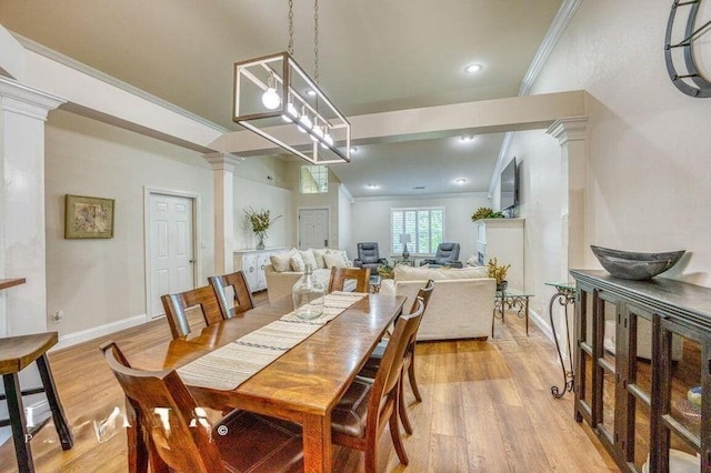 dining space with an inviting chandelier, light hardwood / wood-style flooring, crown molding, and ornate columns