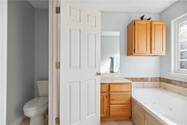 bathroom featuring tile patterned flooring, vanity, tiled bath, and toilet