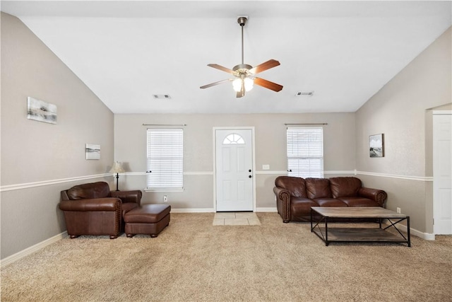 carpeted living room with a wealth of natural light, ceiling fan, and vaulted ceiling