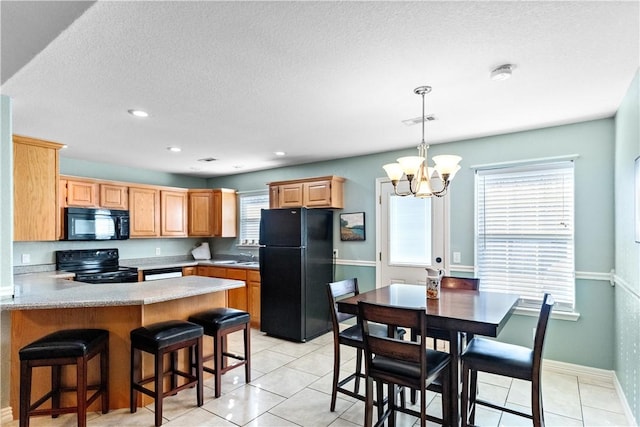 kitchen with black appliances, decorative light fixtures, light tile patterned floors, a textured ceiling, and a notable chandelier