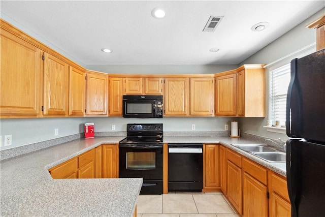 kitchen featuring sink, light tile patterned floors, and black appliances