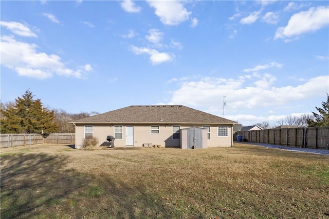 rear view of property featuring a lawn and a shed