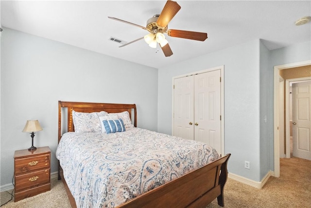 bedroom with ceiling fan, a closet, and light colored carpet