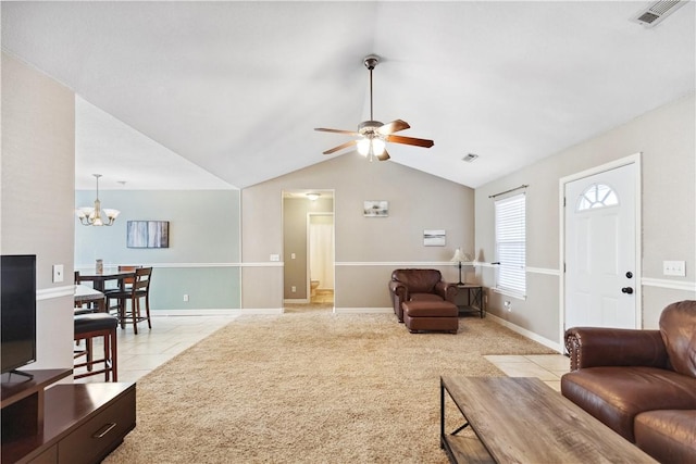 carpeted living room featuring ceiling fan with notable chandelier and lofted ceiling