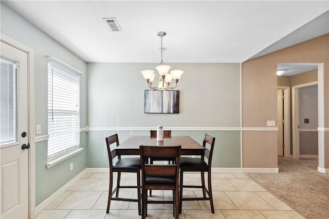 dining area featuring light tile patterned floors and an inviting chandelier