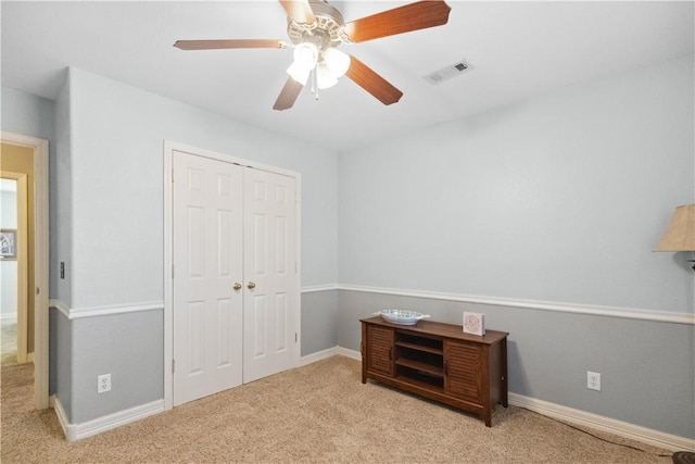 carpeted bedroom with ceiling fan and a closet