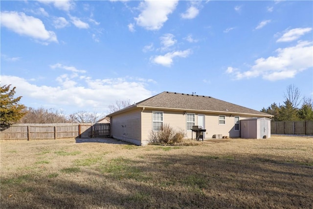 back of property featuring a storage unit and a yard