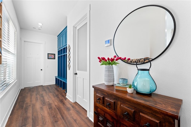 corridor featuring baseboards and dark wood finished floors