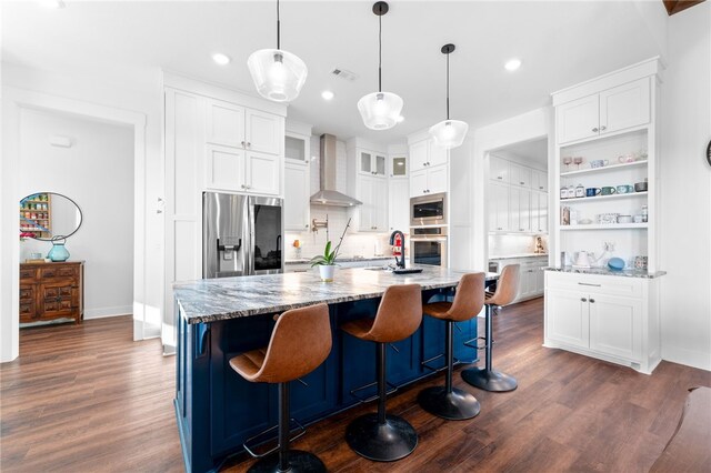 kitchen featuring white cabinets, wall chimney exhaust hood, dark wood-style floors, and appliances with stainless steel finishes