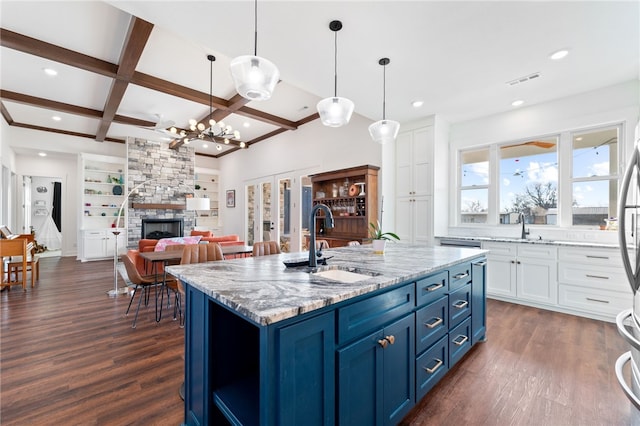 kitchen with white cabinetry, blue cabinets, dark wood-type flooring, and a sink