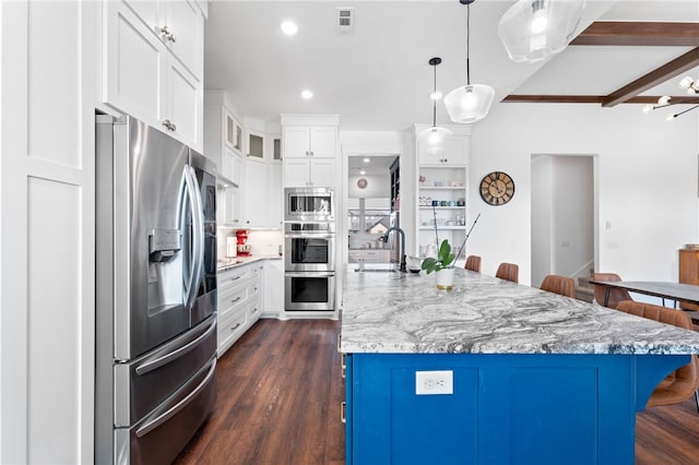 kitchen featuring dark wood-type flooring, a breakfast bar area, white cabinets, stainless steel appliances, and a sink