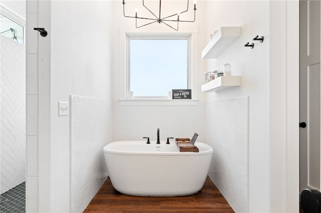 bathroom featuring a freestanding tub, tiled shower, tile walls, and wood finished floors