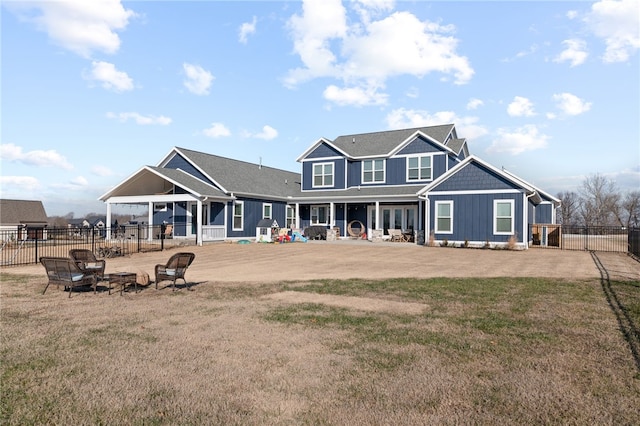 rear view of house featuring a patio area, fence, board and batten siding, and a lawn