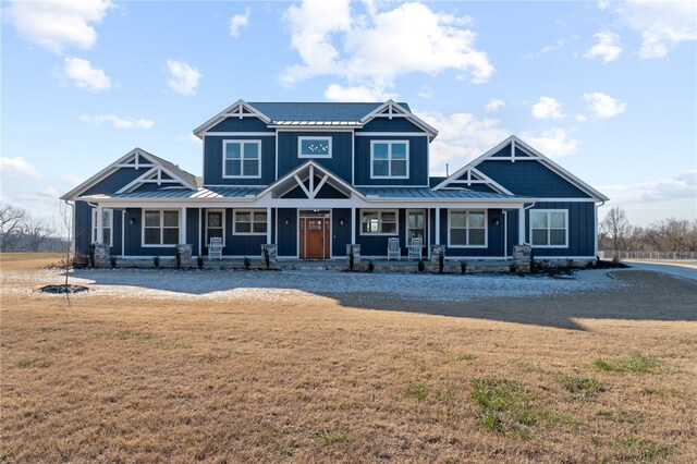 craftsman inspired home featuring covered porch and a front yard