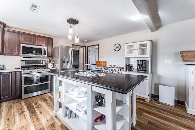 kitchen featuring white cabinetry, a kitchen island, appliances with stainless steel finishes, beam ceiling, and dark brown cabinetry