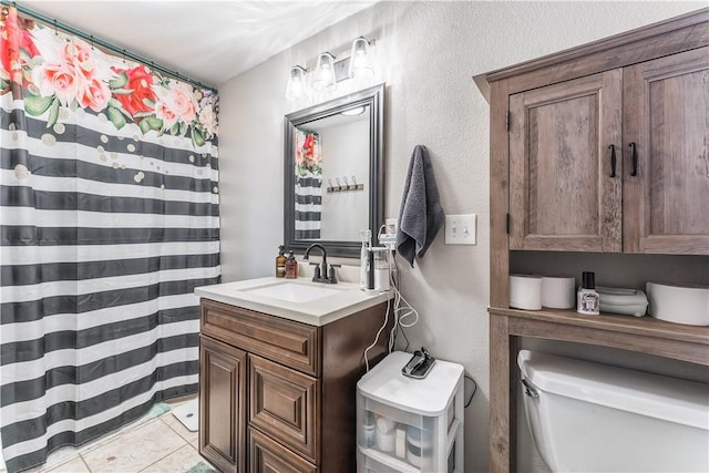 bathroom featuring vanity, tile patterned floors, and toilet