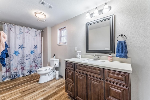 bathroom with a shower with shower curtain, vanity, hardwood / wood-style flooring, and toilet