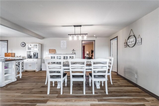 dining area featuring beam ceiling and dark wood-type flooring