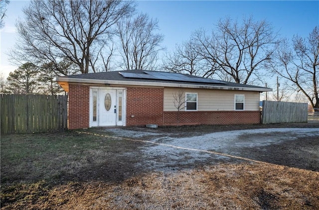 single story home featuring solar panels