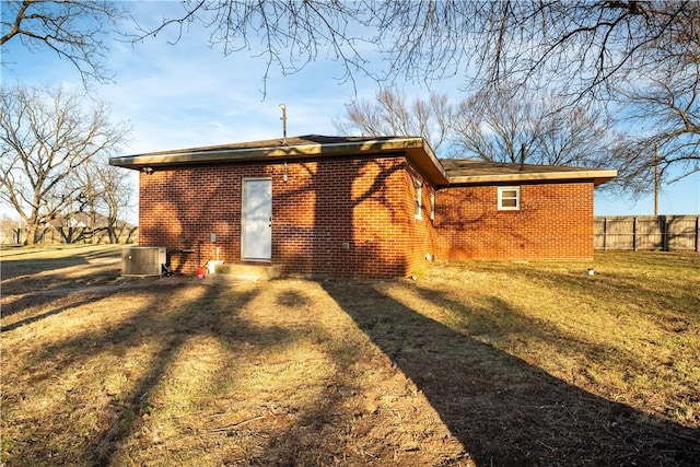 rear view of property with a yard and central AC