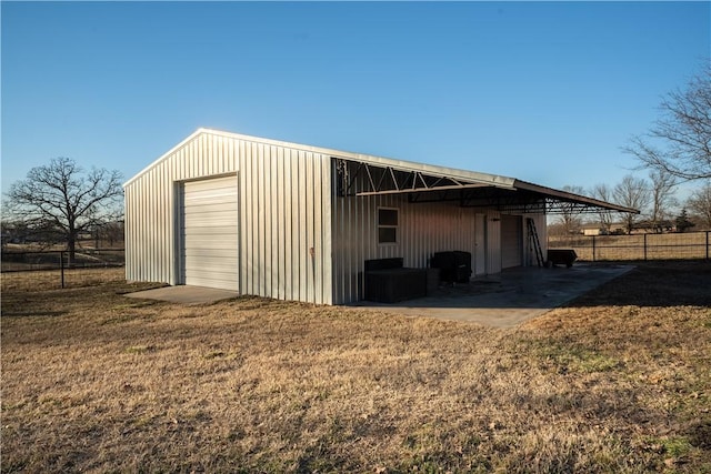 view of outdoor structure featuring a garage and a lawn