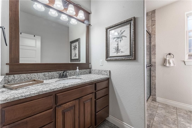 bathroom with baseboards, a shower stall, vanity, and tile patterned floors