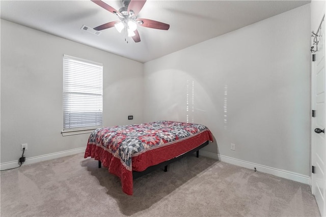 bedroom featuring baseboards, a ceiling fan, visible vents, and light colored carpet