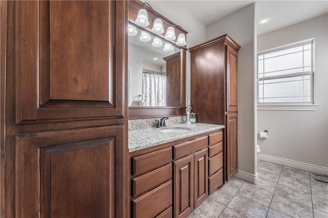 full bathroom featuring vanity, baseboards, and tile patterned floors