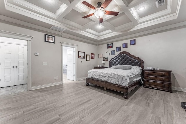 bedroom featuring light wood-style floors, visible vents, and crown molding