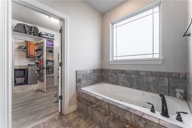 bathroom featuring tile patterned flooring, a garden tub, and a spacious closet